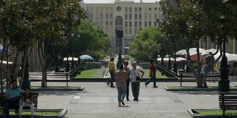 A group of older women taking a photo in a plaza in front of a large building