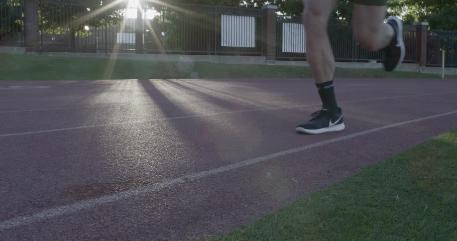 A man running along an outdoor track during the day