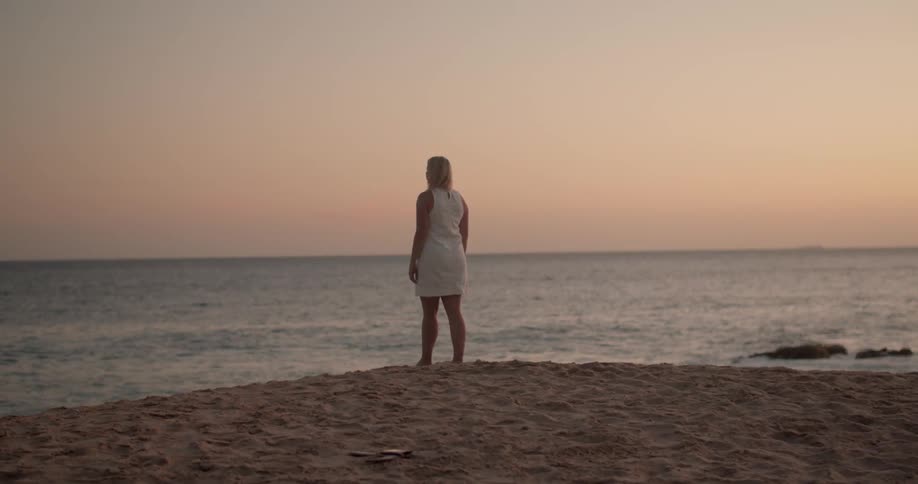 A woman looks out over the ocean