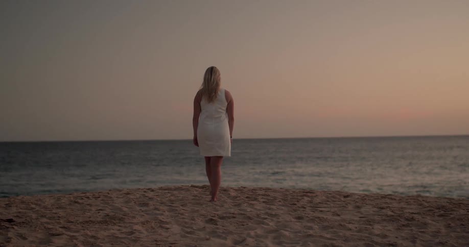 A woman walks along the beach