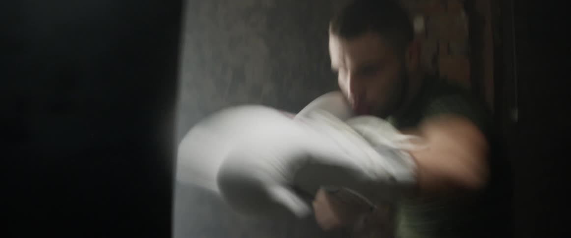A man is punching a heavy bag in the gym