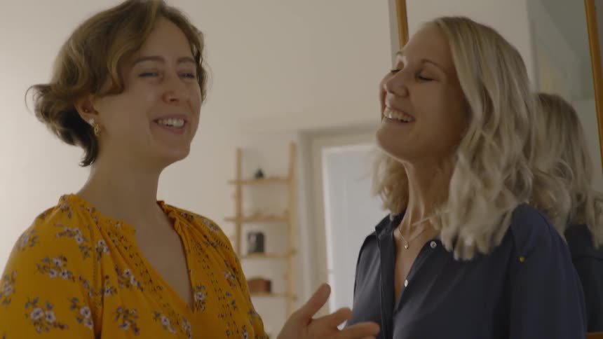 Woman chats about mobile phone with pregnant woman