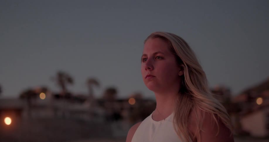 A woman is looking outdoors at night