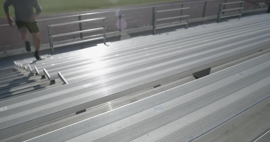 A man runs up the bleachers at a stadium