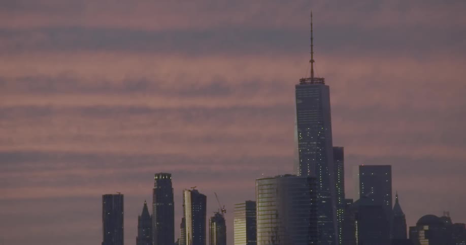 Gray skyscrapers under a cloudy evening sky