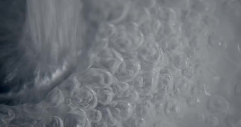 Water coming out of a faucet so fast it produces bubbles