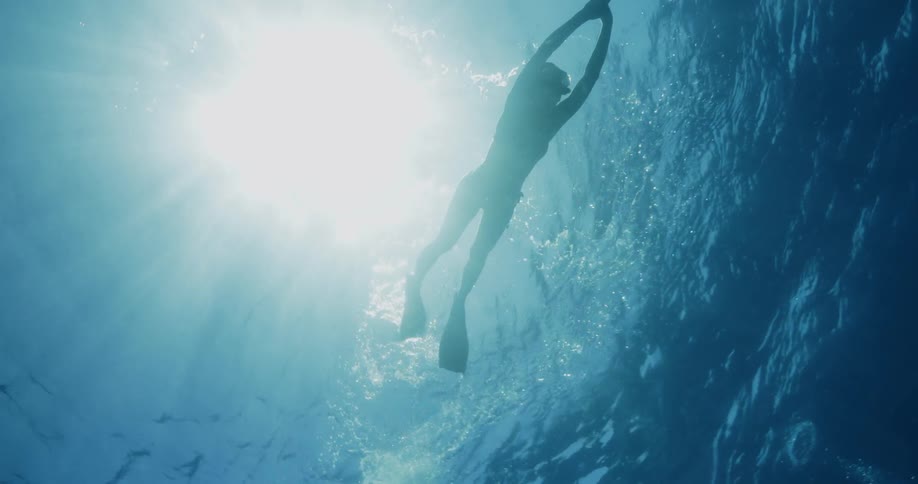 A woman swimming on top of clear water