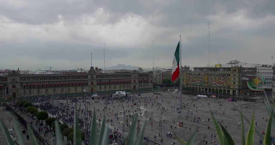 A large group of people standing in an open center if a city