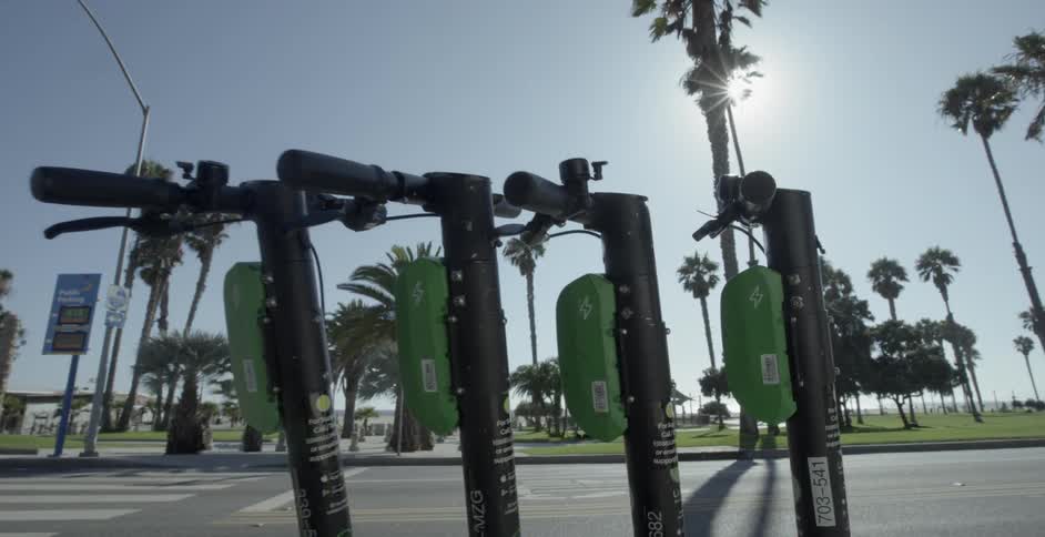 People riding scooters down the street