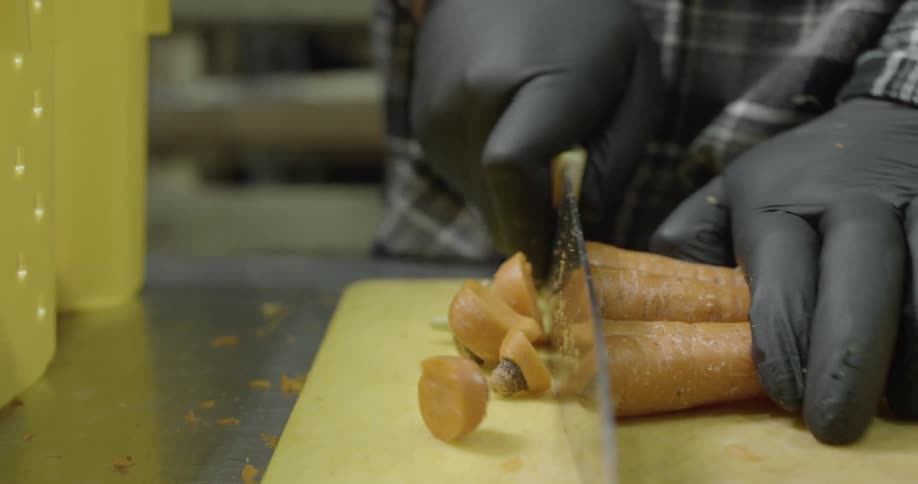 A man is cutting carrots with a knife