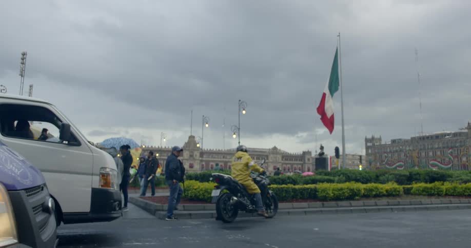 A man on a motorcycle moves to the side of the road out of the way of traffic