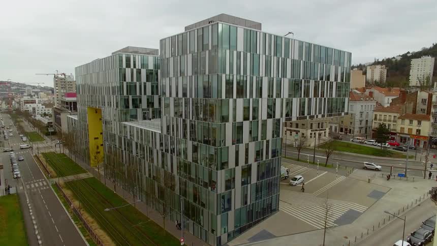 A mirrored office building in the middle of a city