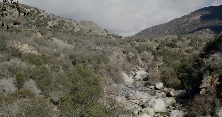 A small stream with hills and the sky in the background