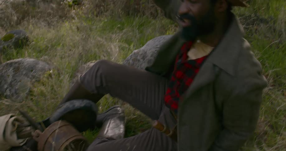 A man takes off a pack and sits down