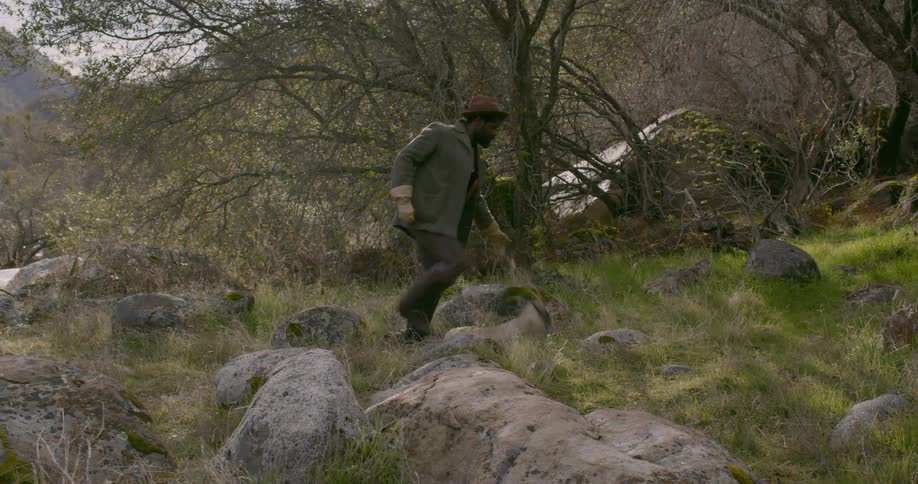 A man walks through nature then collapses in exhaustion