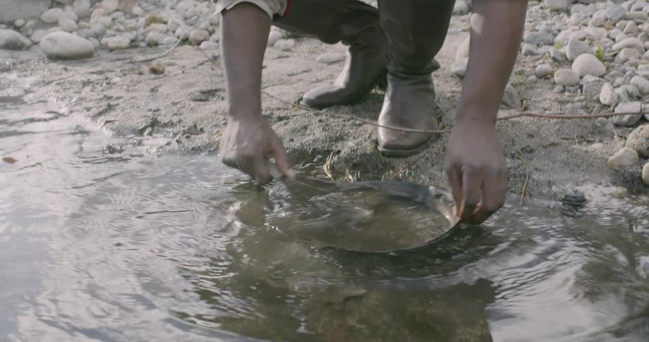 A man near a river panning for gold