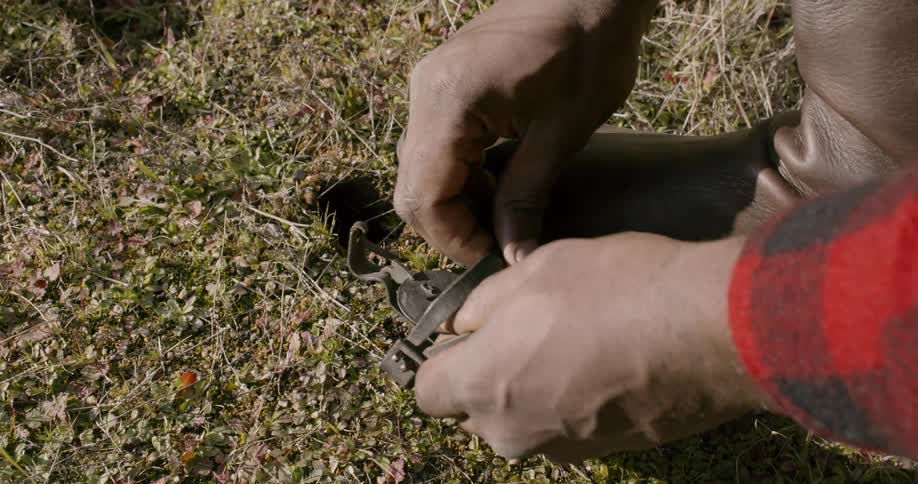 A person is opening a trap with his boot