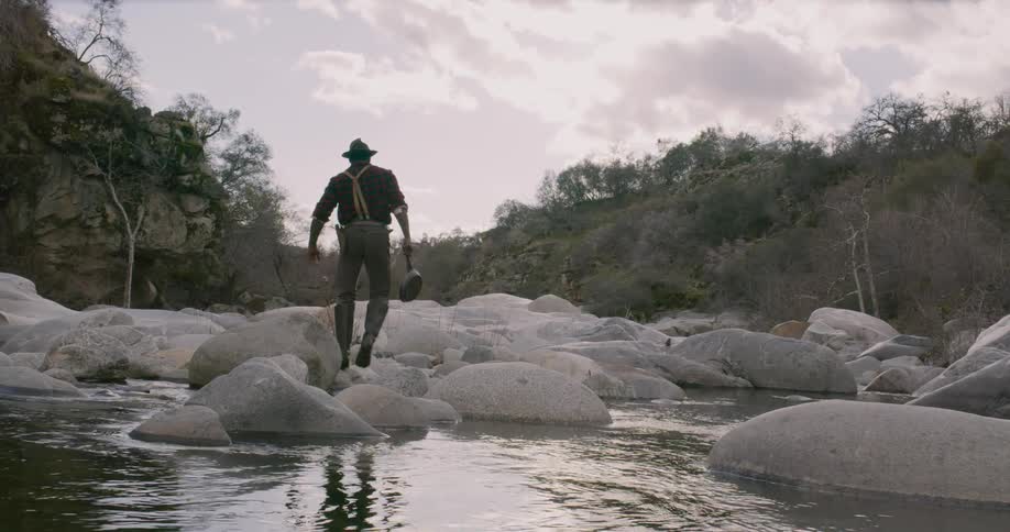 A man climbs over the ice near the water