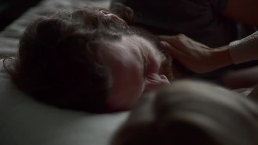 A man and woman laying next to each other in bed