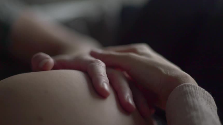 A person is touching a womans stomach