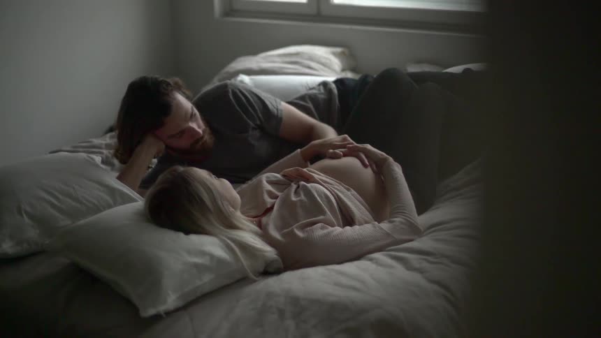 A man and woman lay in bed together