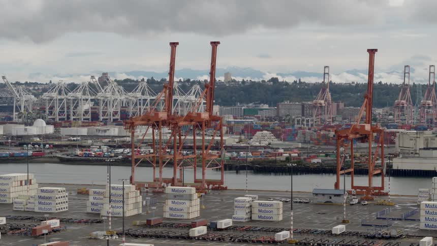A dockyard filled with shipping containers on a cloudy day