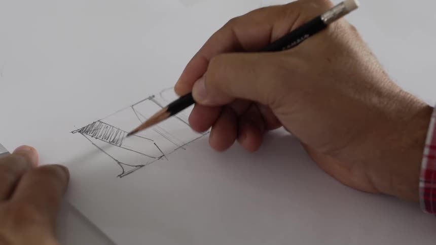 Man sketches with a pencil on a white paper
