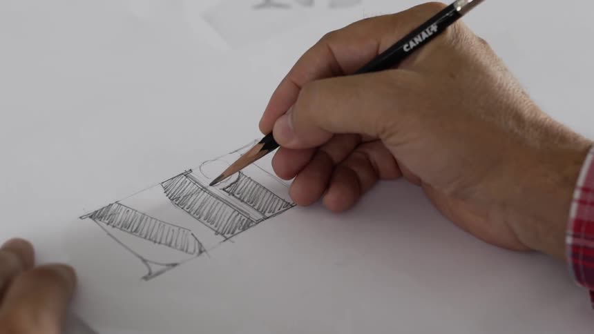 A man draws a logo on paper