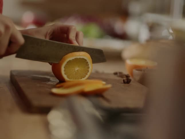 A person slices an orange with a knife