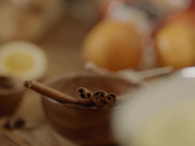 Cinnamon sticks sit in a bowl on a table