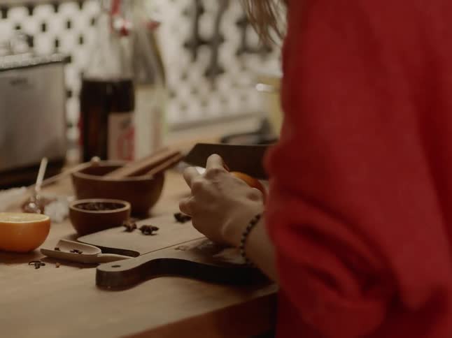 A caucasian female chopping food on a cutting board