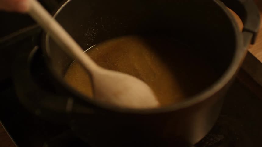 A person is mixing gravy in the pot