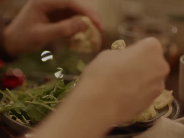 A person eats hummus off a plate