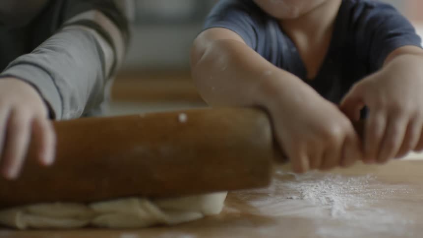 Children roll out dough with a rolling pin