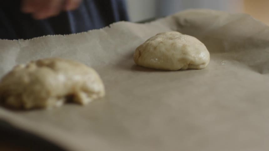 A people put dough on a sheet to bake