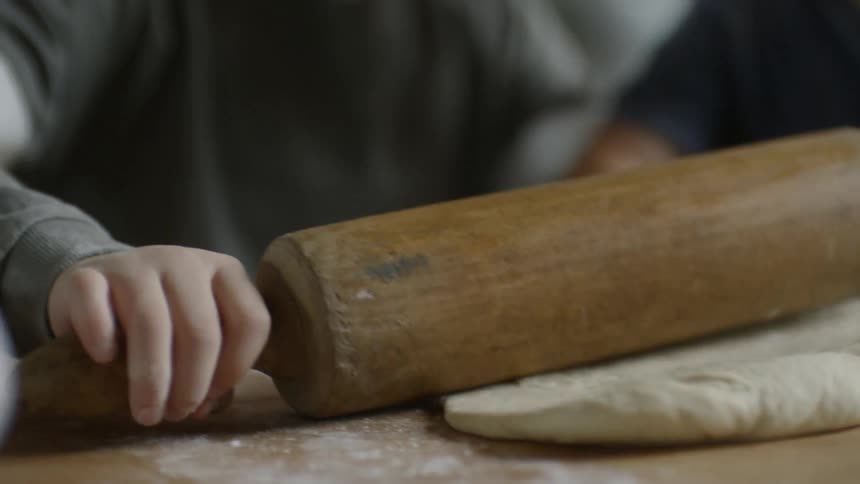 Children roll out dough with a rolling pin