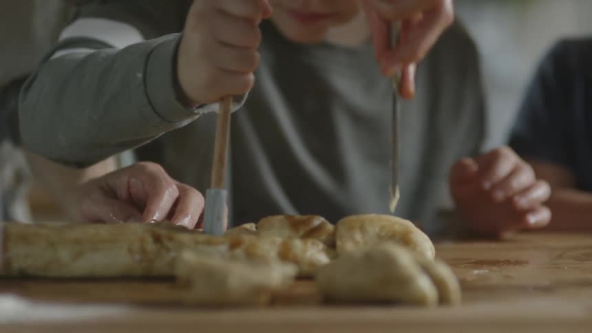 People stab dough with utensils