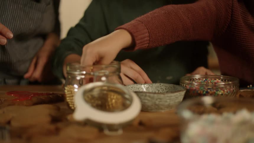 A person reaches into a dish for beads