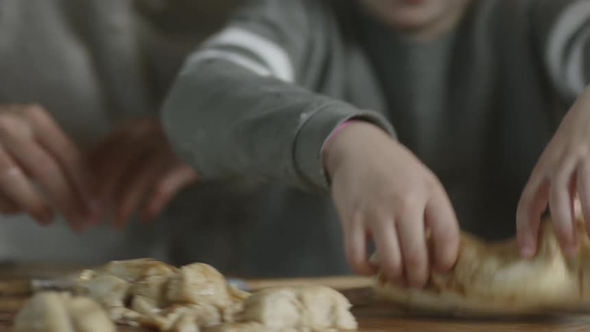 A child picks up a hunk of dough