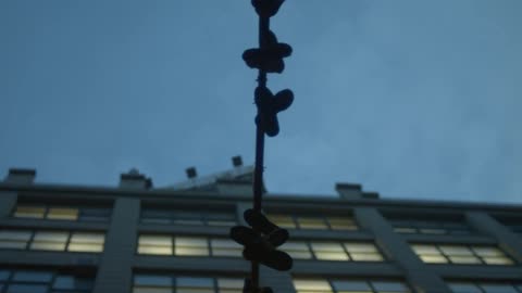 Shoes hanging from a pole in a city