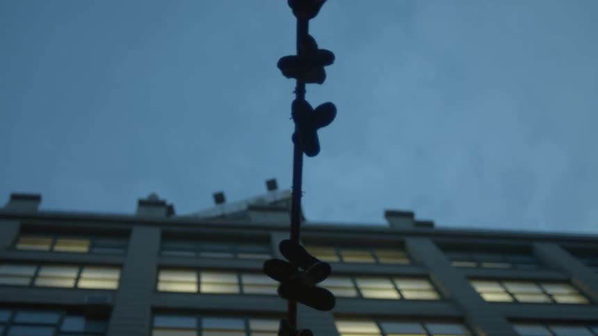 Shoes hanging from a pole in a city