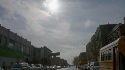 Cars line a city street on a sunny day
