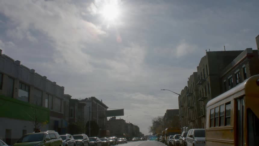 Cars line a city street on a sunny day
