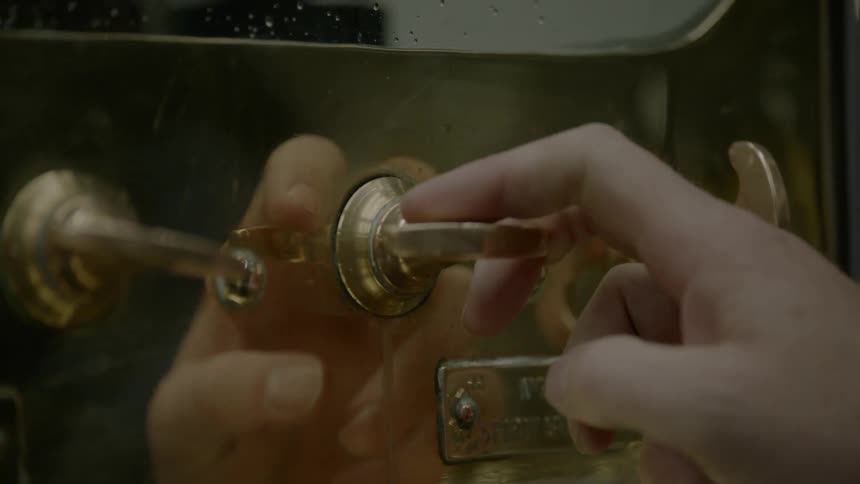 Person turns handle on distillery machine