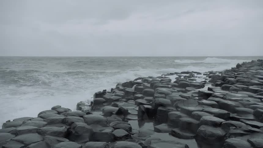 Waves roll in against the rocky shore on the giants causeway