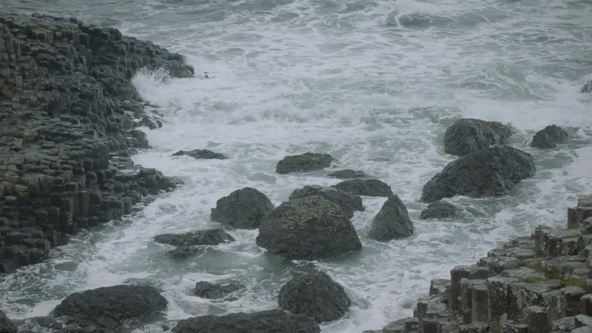 Waves roll in against the rocky shore on the giants causeway