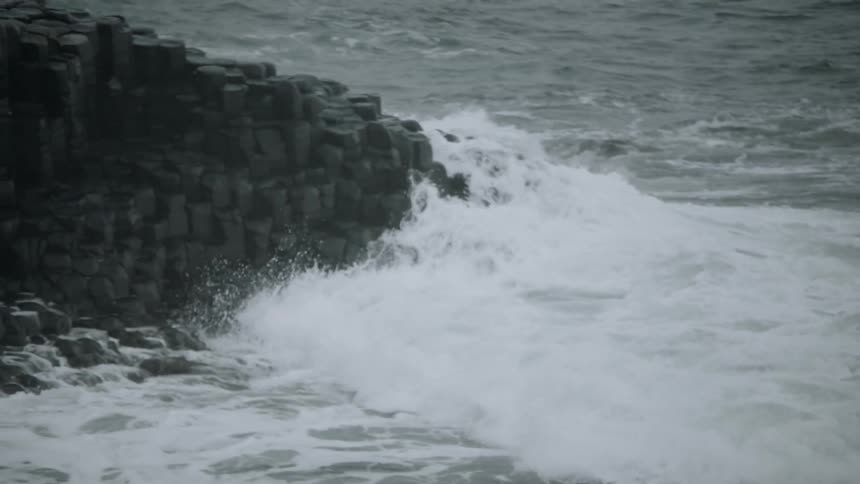 Waves moves forward and crash on the rocky coast line