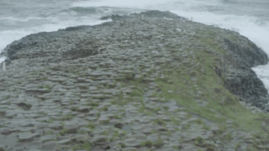 Waves roll in against the rocky shore on the giants causeway