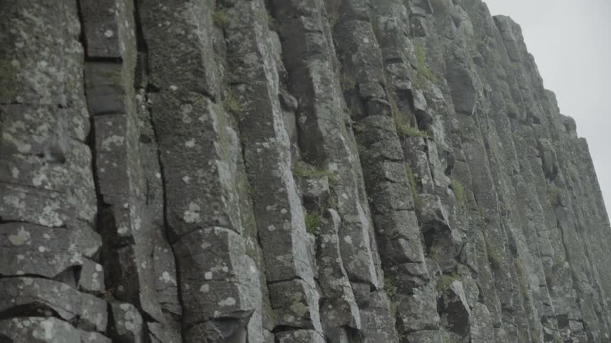 The steep and jagged rock face of a cliff