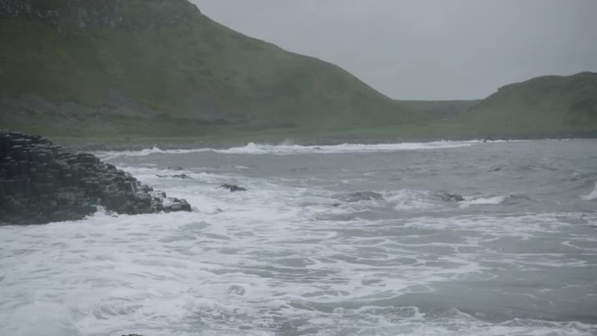 Wide shot of waves crashing along coastline